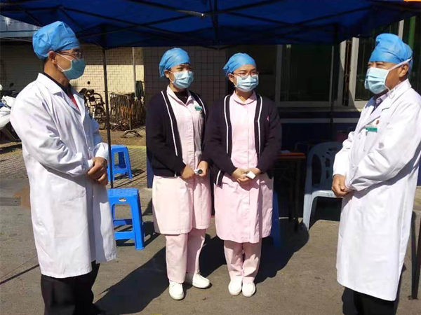 3.盧軍敏（左一）在臨時測量體溫點布置工作_副本.png